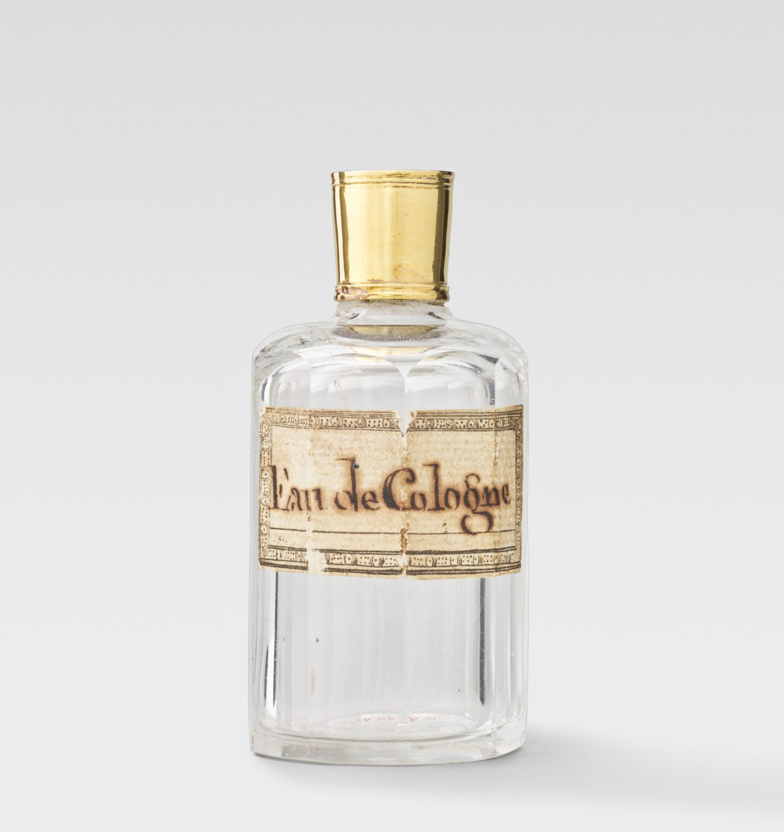 Flacon cylindrique de cristal taillé.
Bouchon de cristal coiffé d'un bouchon de vermeil.