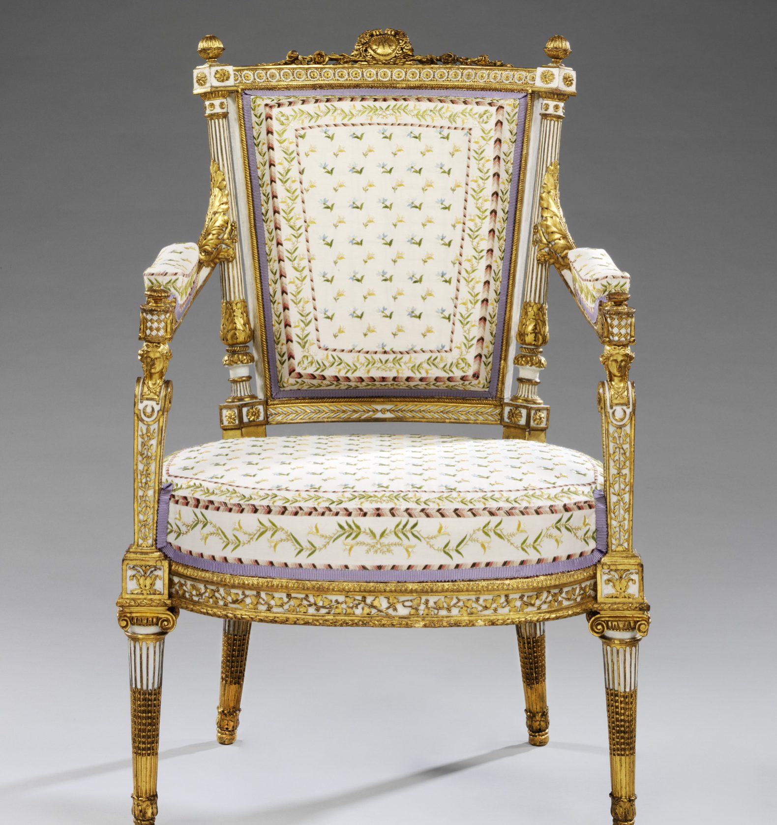 Armchair
Of carved walnut, with the monogram MA in the cresting, painted white, and partly gilded, Paris, late 1780s
Jean-Baptiste-Claude Sené (1748-1803), almost certainly made by Jean-Baptiste-Claude Sené. (master 1769)
Original painting and gilding by Louis-Francoise Chatard c.1749-1819, master 1775
Paris
1788
This entry will be revised following conservation
Carved walnut, painted white and grey and partly gilt, with modern silk upholstery and modern castors